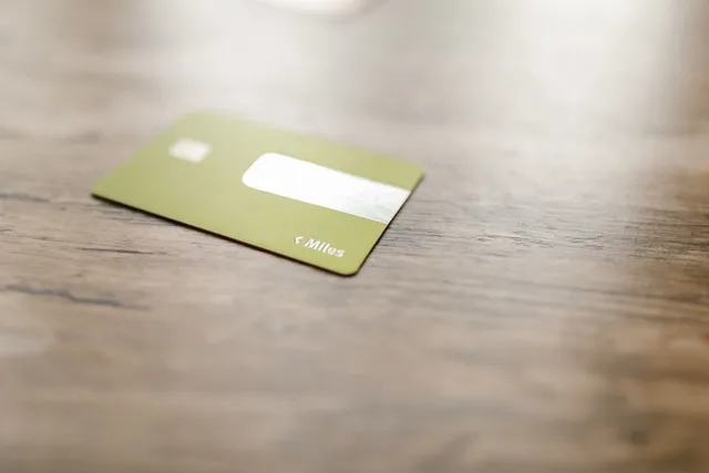 Green credit card placed on a wooden surface, captured with a blurred focus for a modern, minimalistic feel. Business account payment limits: what shapes them